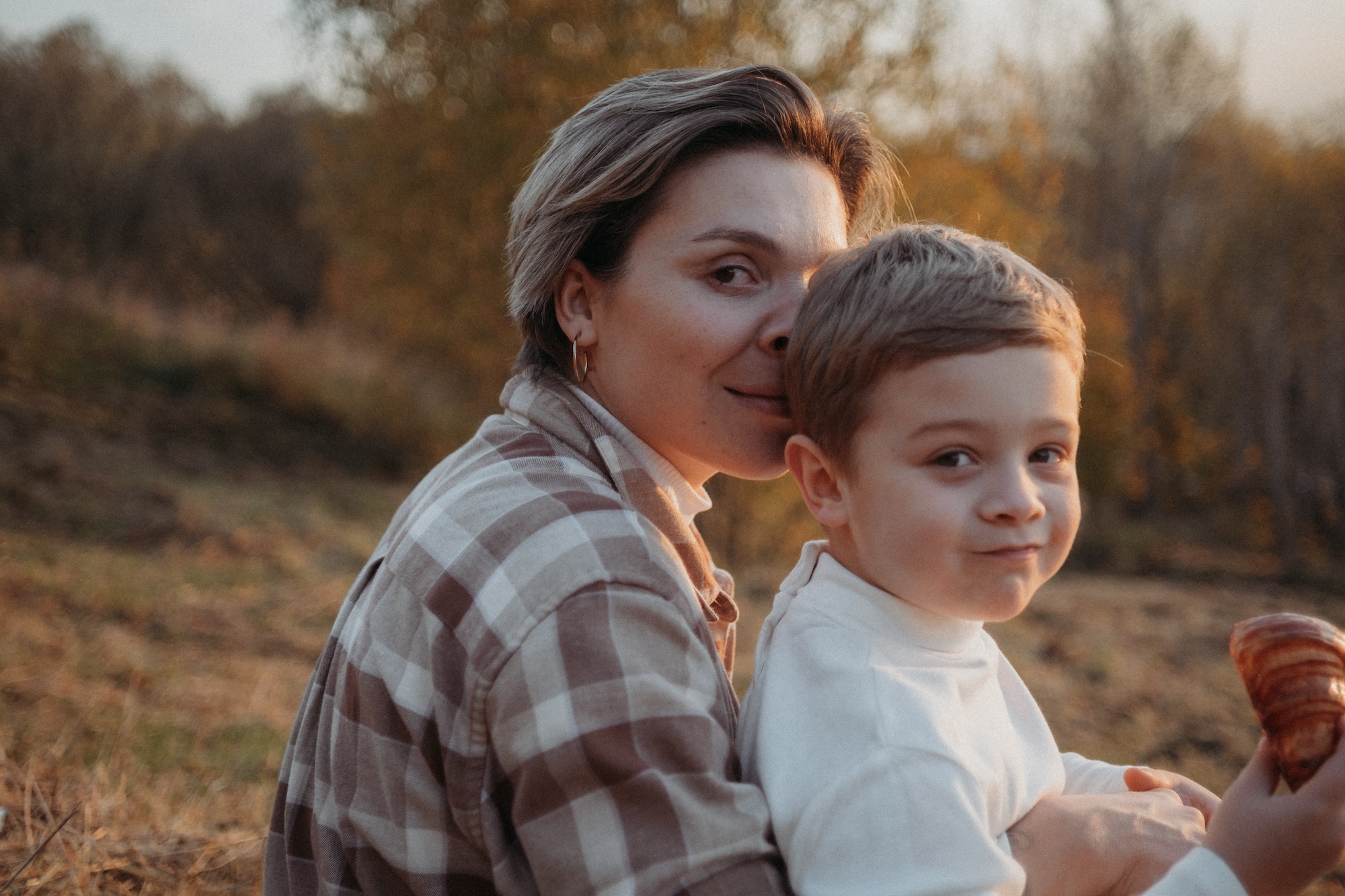 Mother and toddler son sitting outdoors together having a talk